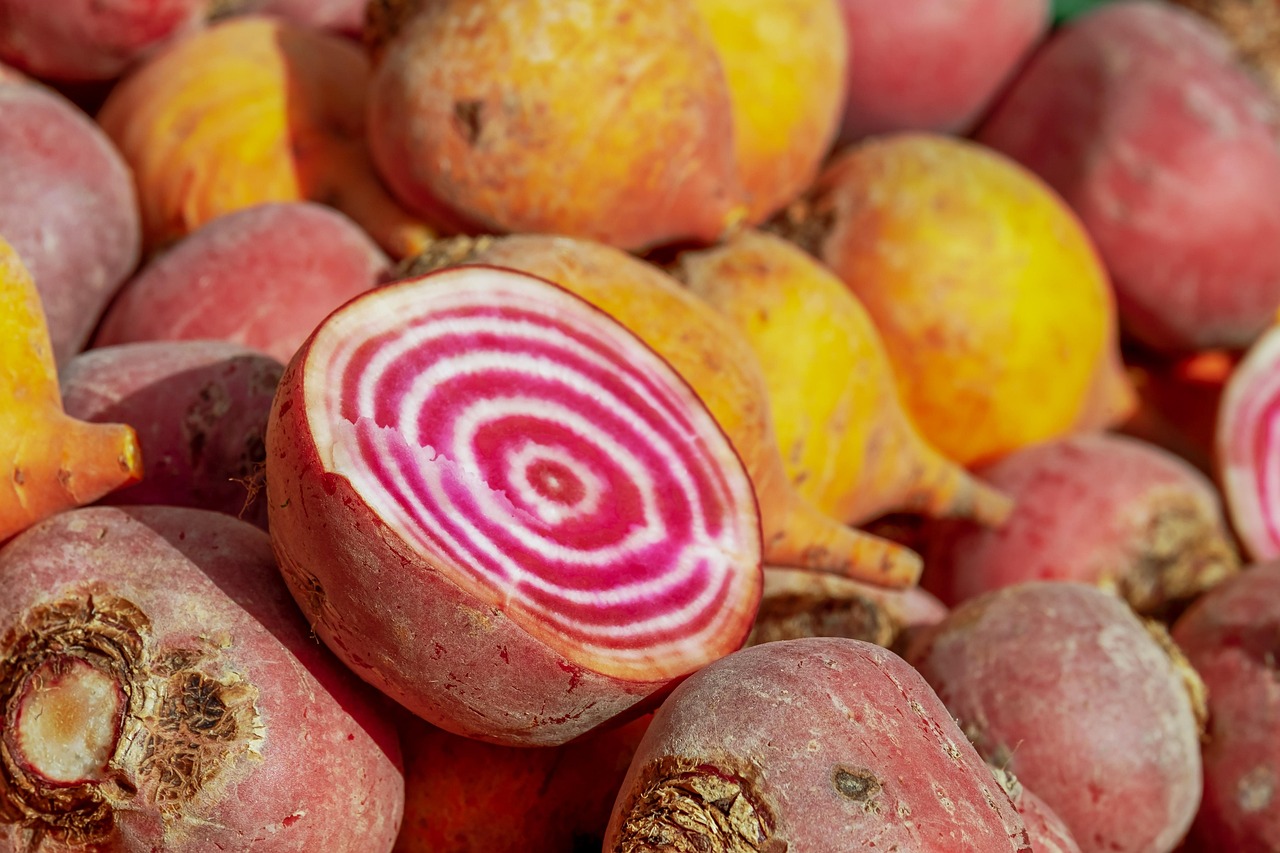 A pile of beets with one Chioggia Beet cut open